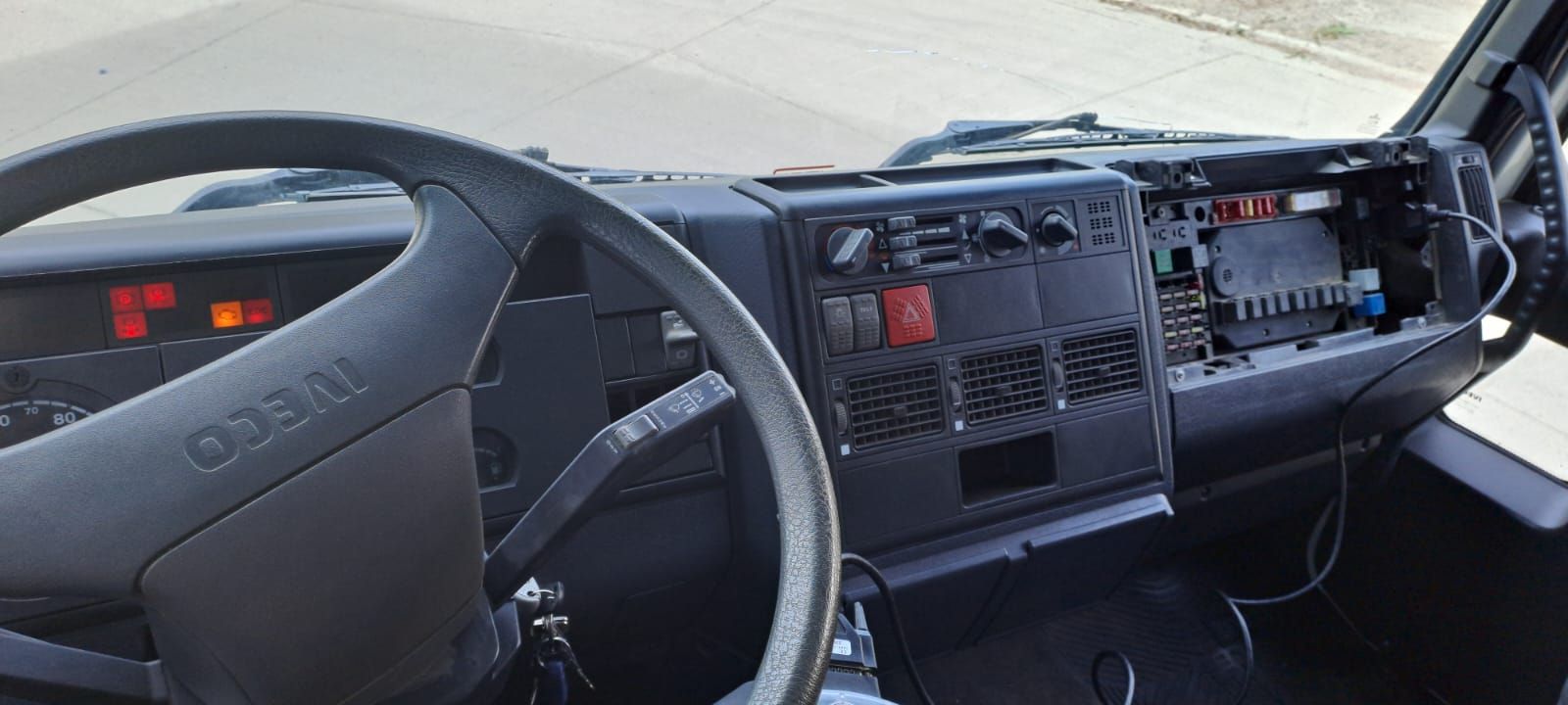 Vista del tablero y el volante de la cabina del camión desde el asiento del conductor