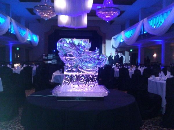 Blue-lit banquet hall with a large crystal centerpiece on a round table