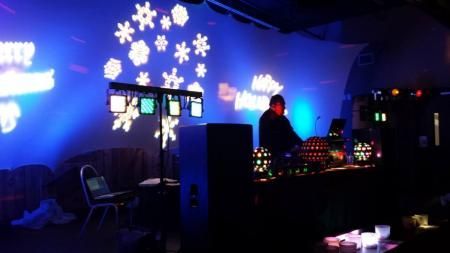 Dimly lit nightclub with blue lighting, snowflake wall decorations, and glowing DJ equipment.