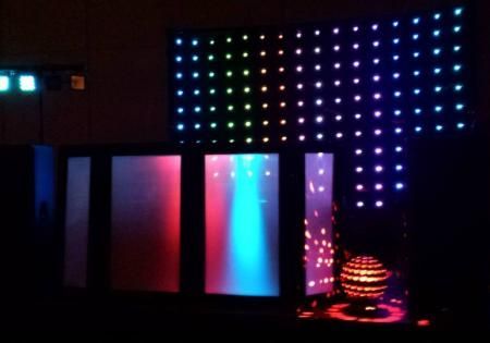 Colorful LED-lit abstract display with glowing panels and a dotted light wall on a dark stage
