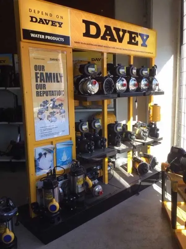 Davey water products display with rows of pumps and tools on shelving in a store showroom
