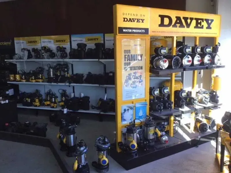 Davey display of fishing reels on black shelves in a store, with yellow signage and multiple reel models.