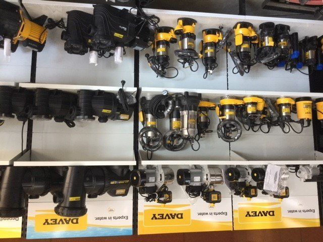Shelves stocked with rows of yellow-and-black fishing reels in a store display