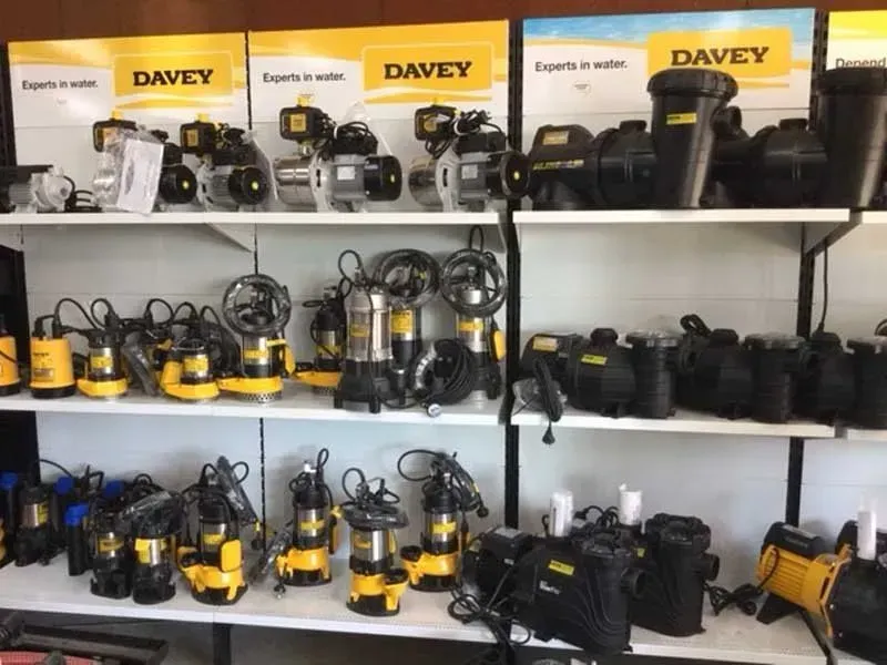 Shelves of yellow and black Davey water pumps and motors in a store display