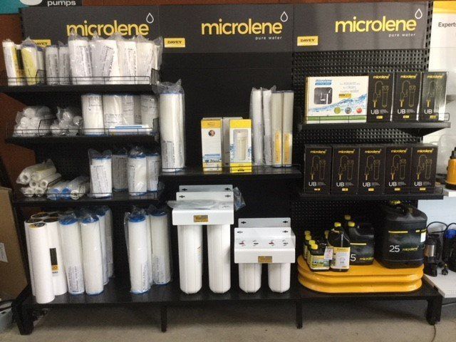 Microlene water filtration display with white filter cartridges and black/yellow units on store shelves