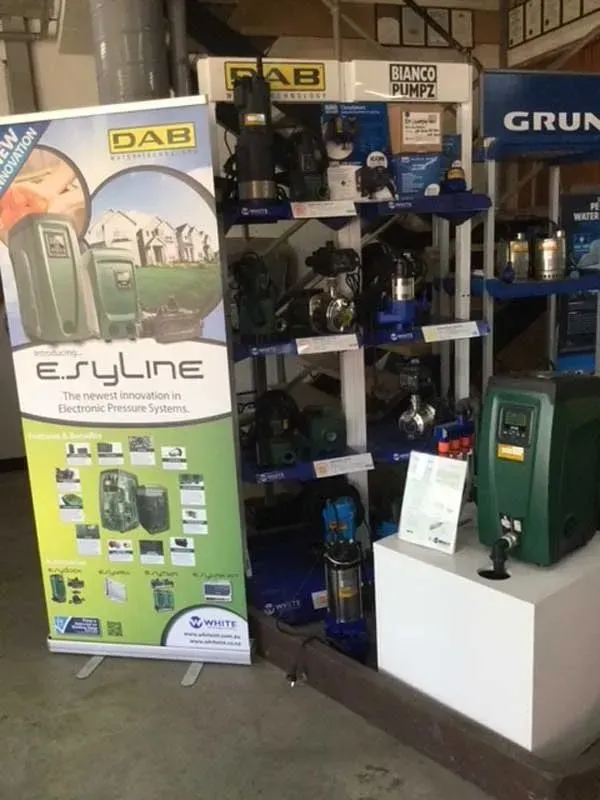 Booth display with DAB E-Syline posters, blue equipment, and a white counter in a showroom.