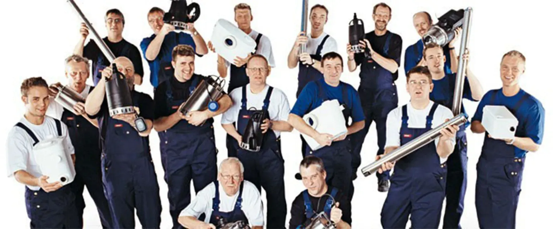 Group of uniformed people holding large white tube-shaped tools against a plain white background