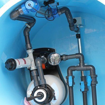 Blue mechanical tubing and valves inside a machine housing, with a white circular component.