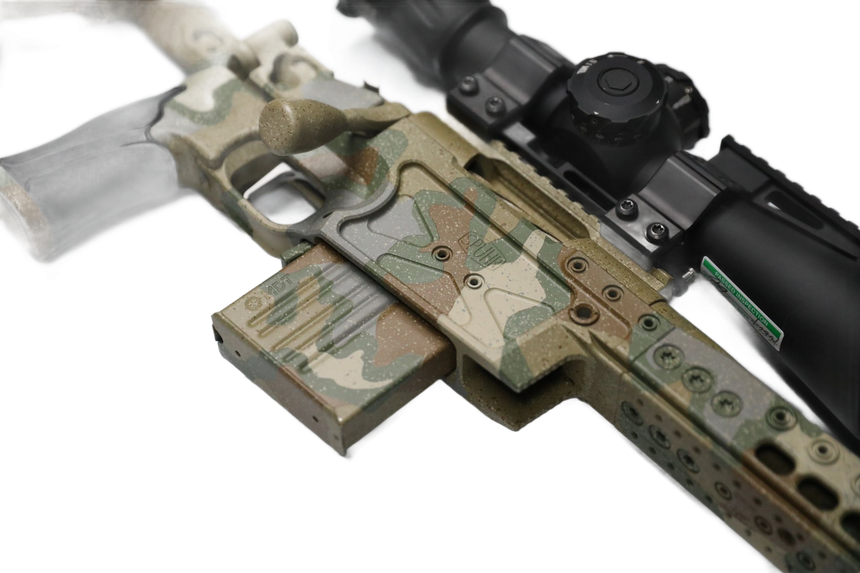 Camouflage-patterned rifle with a scope, magazine attached.