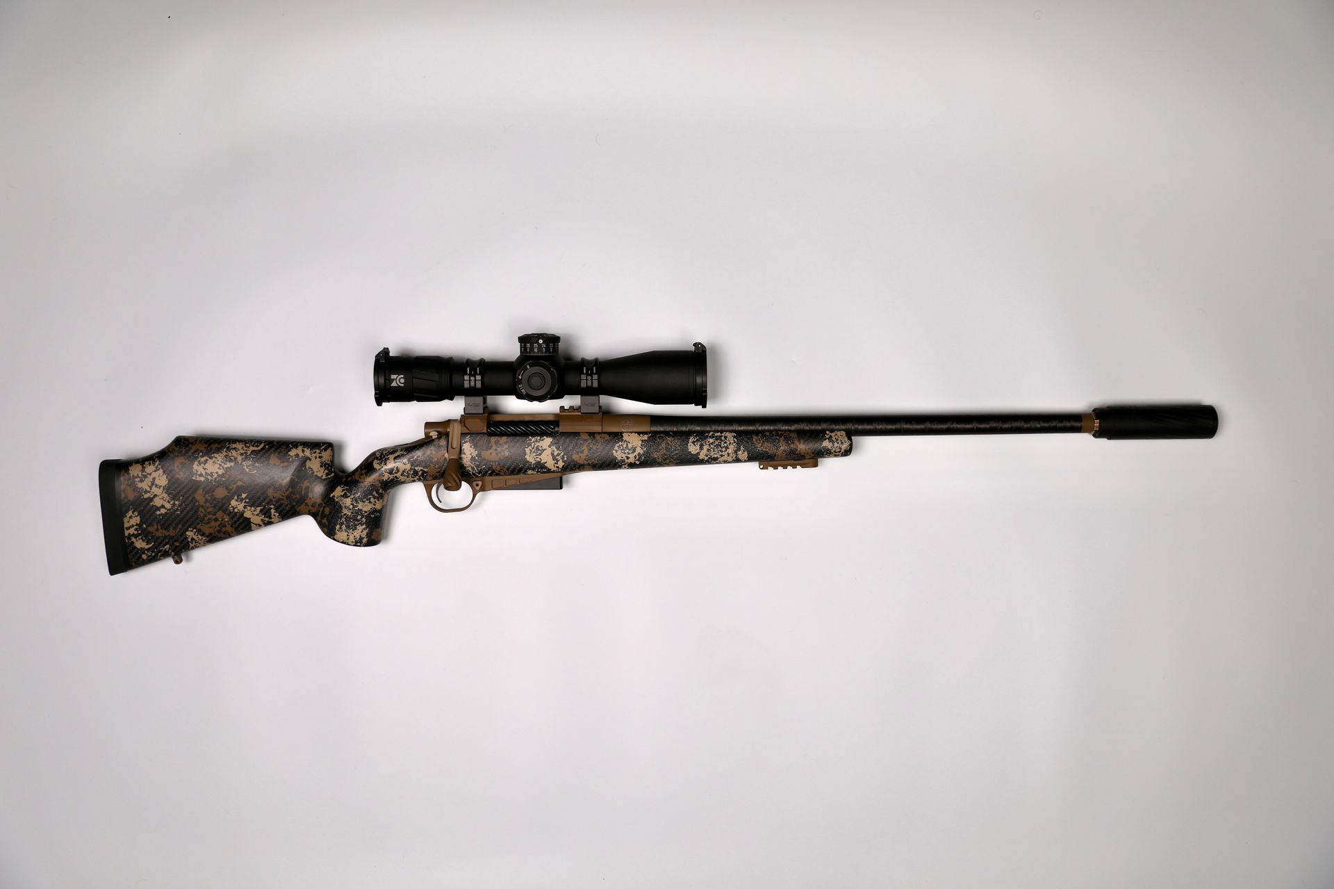 Rifle with scope and silencer on a white background, camouflage pattern on stock and barrel.