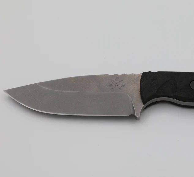 Close-up of a fixed-blade knife with a black handle and a silver blade, marked 