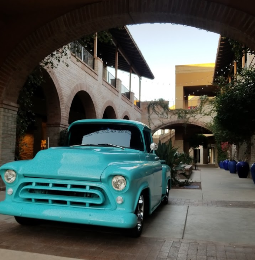 Turquoise vintage truck parked under an archway in a brick courtyard.  | Top Notch Autocare