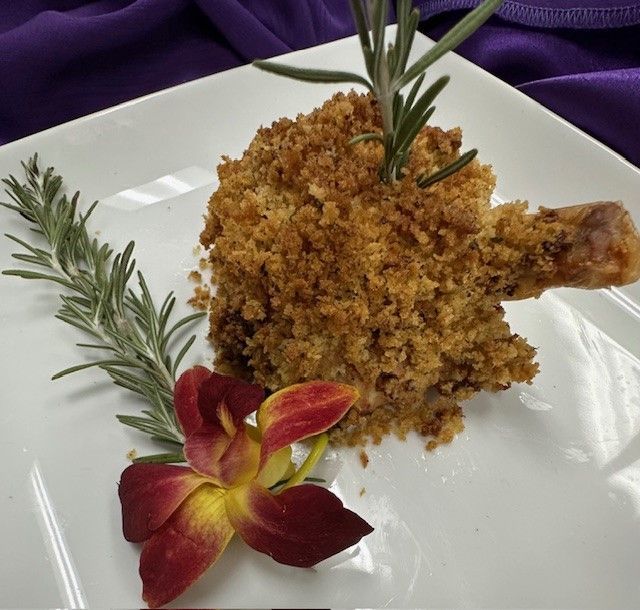 A plate of food with rosemary and flowers on it