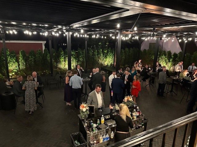 A group of people are standing around a bar at a party.