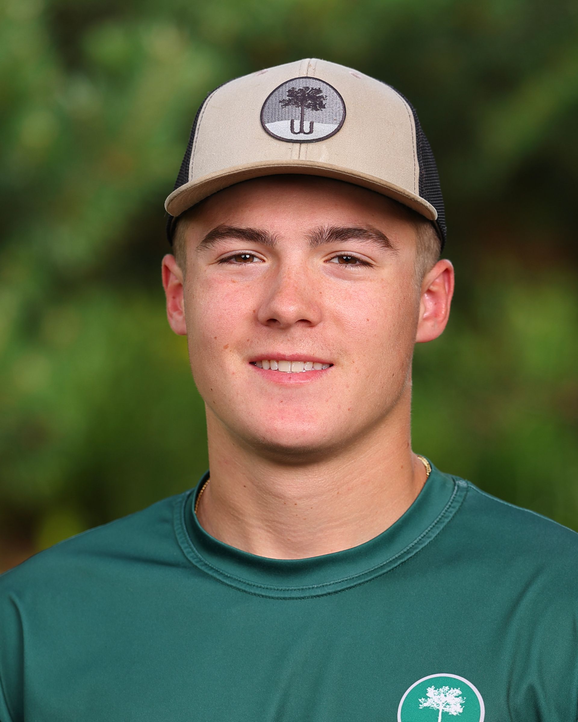 A young man wearing a hat and a green shirt