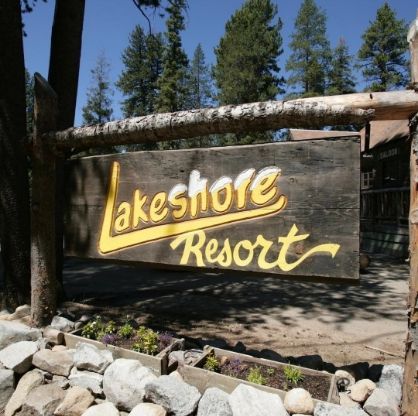 Sign for Lakeshore Resort, with yellow lettering and a wooden frame.