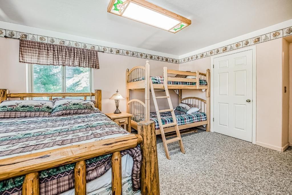 Shared bedroom with two bunk beds, a window, and a white closet on a patterned carpet.