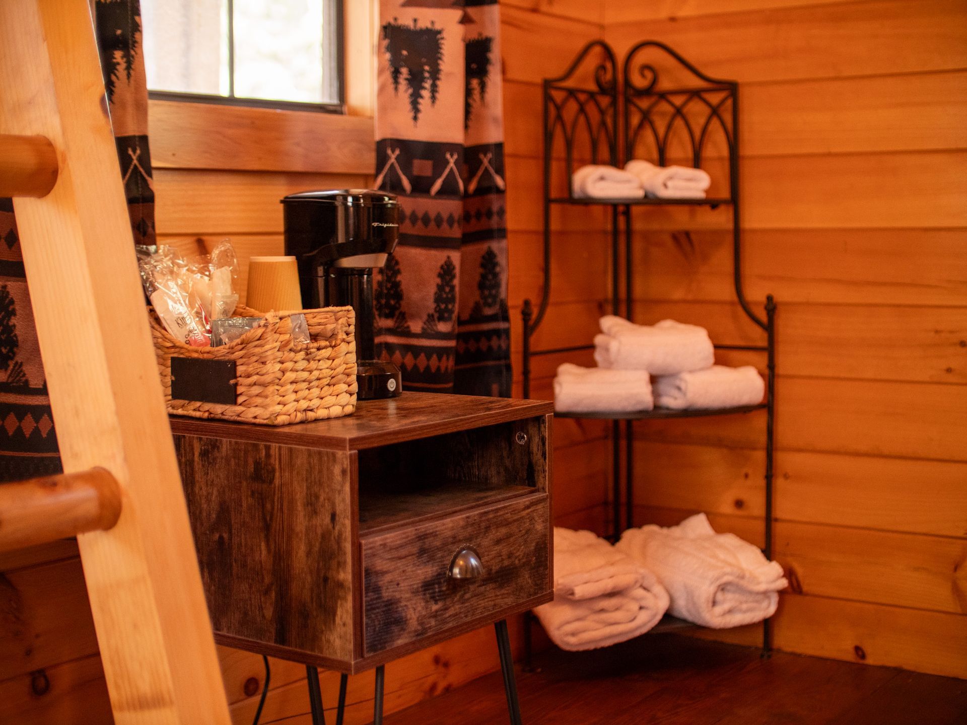 Wooden sauna interior with towels, a basket, and metal shelving by a window