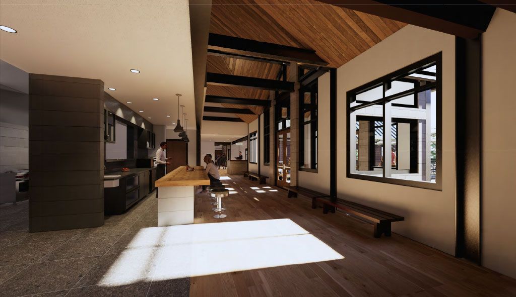 Interior of a modern building with a wooden ceiling and large windows, with sun shining on the floor.