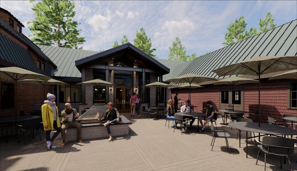 Outdoor dining area with tables, umbrellas, brick buildings, and people socializing.
