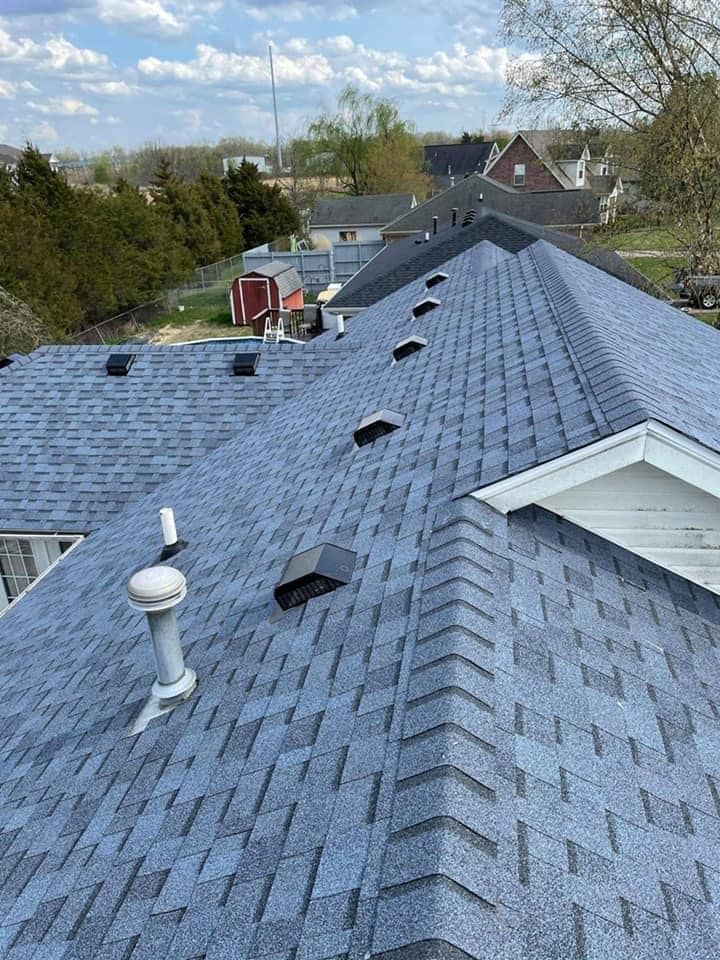 The roof of a house with a blue shingle roof.