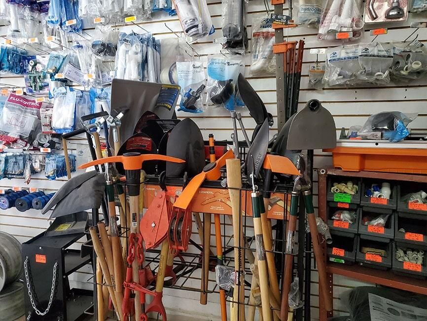 Un montón de herramientas están alineadas en un estante en una tienda.
