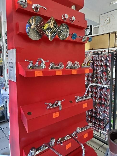 Una exhibición de grifos en una pared roja de una tienda.