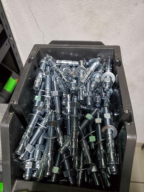Una caja llena de muchos tornillos y pernos de metal.