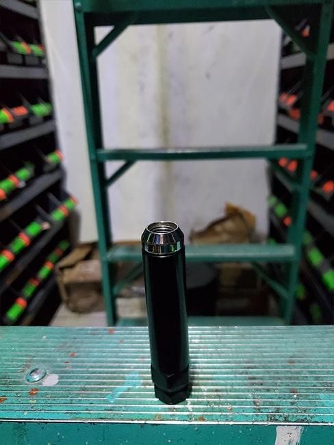 Una nuez negra está encima de un estante verde en un almacén.