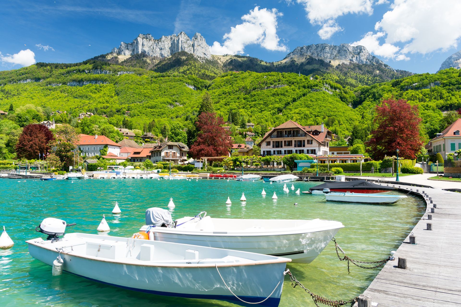 A couple of boats are docked in a lake with mountains in the background.