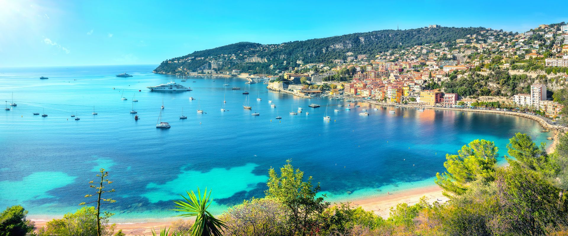 A large body of water with boats in it and a city in the background.