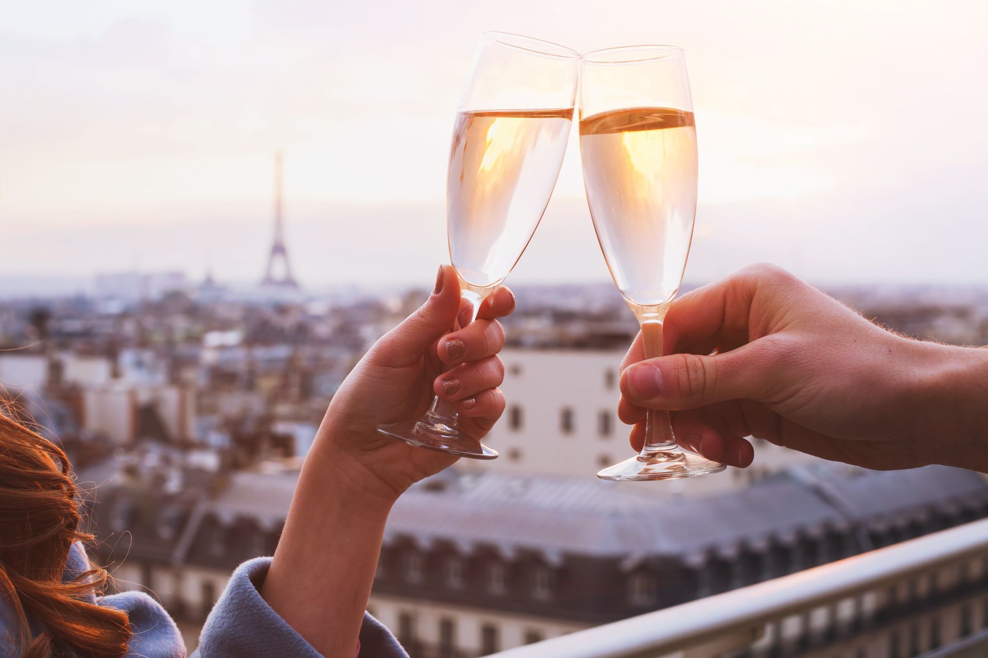 A man and a woman are toasting with champagne glasses in paris.