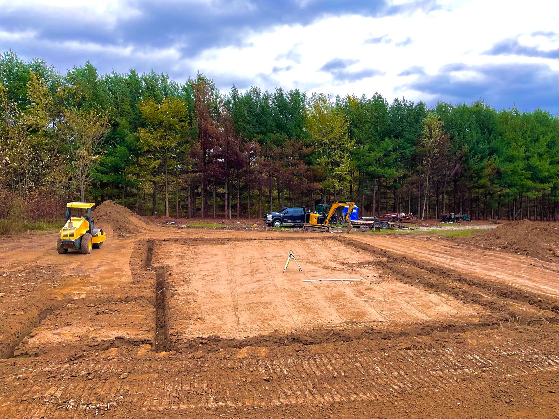 A man wearing gloves is driving a bulldozer on a construction site.