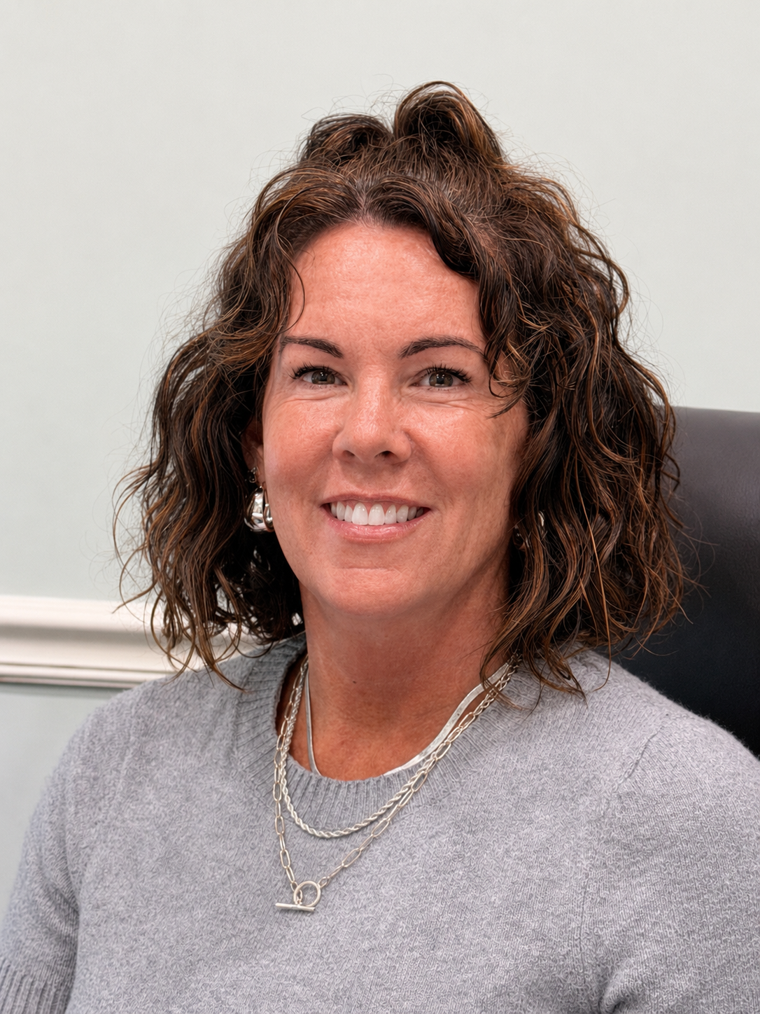 A woman in a black shirt is smiling for the camera.