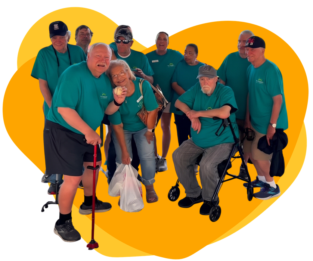 Group of people in teal shirts posing together against a bright yellow heart background.