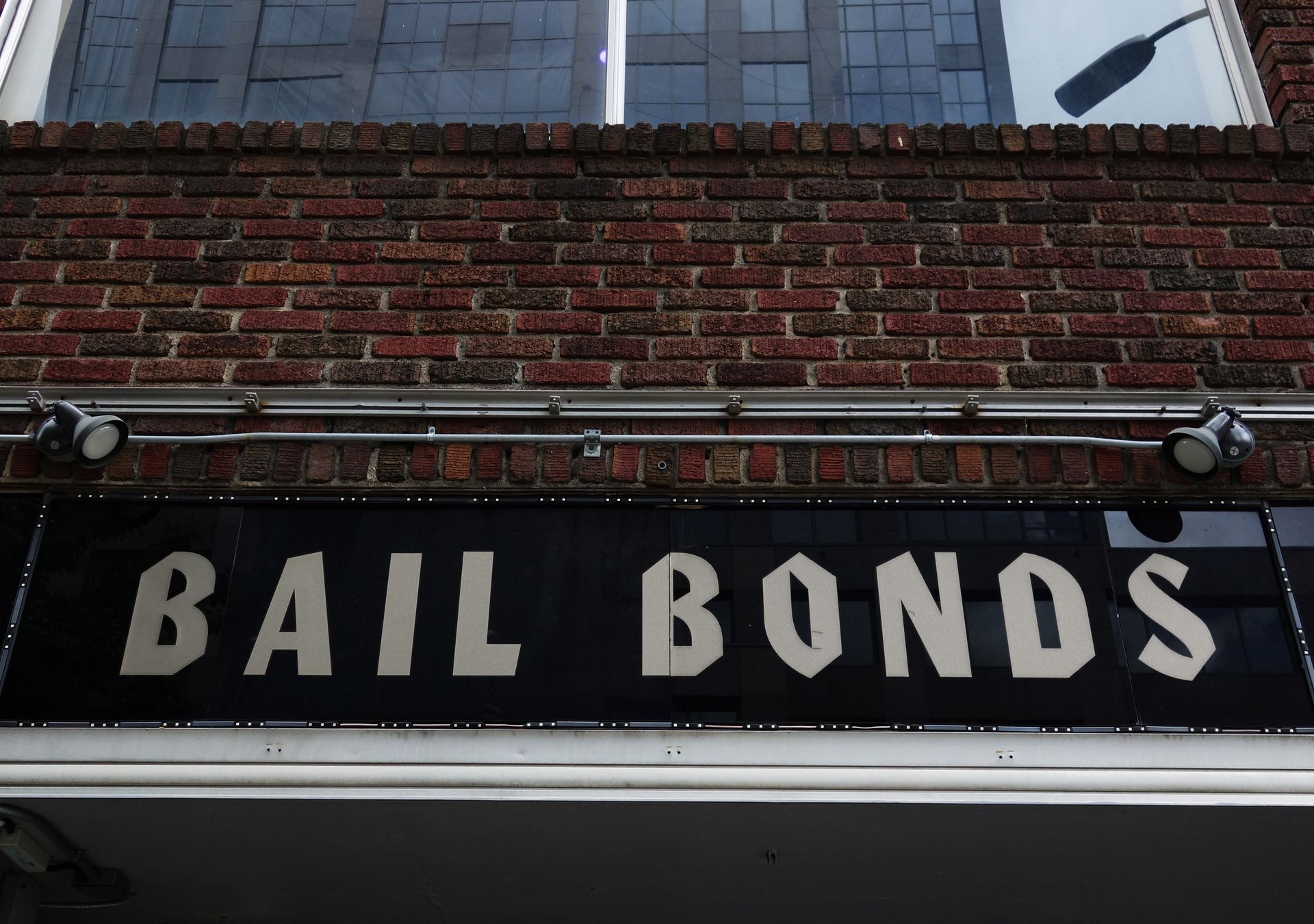 Bail bonds storefront sign in white letters on a black awning above a brick building