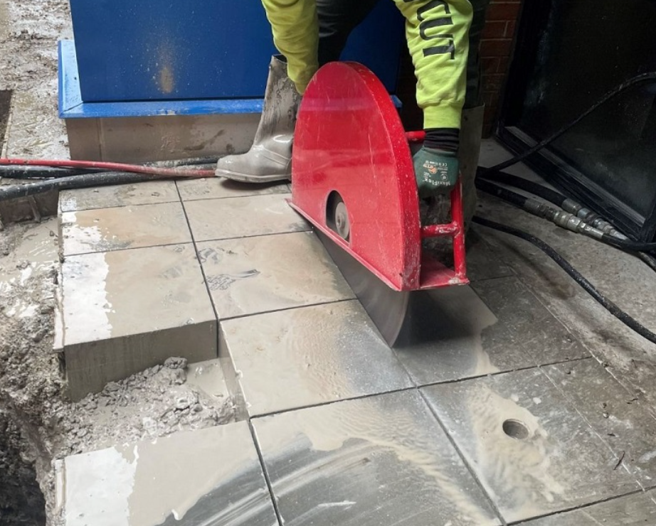 A person is cutting a tile floor with a circular saw.