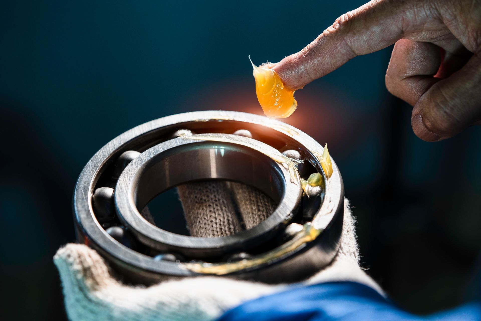 A Gloved Hand Applies Orange Grease To A Metal Ball Bearing — Eastcoast Bearings & Hydraulics in Yamba, NSW