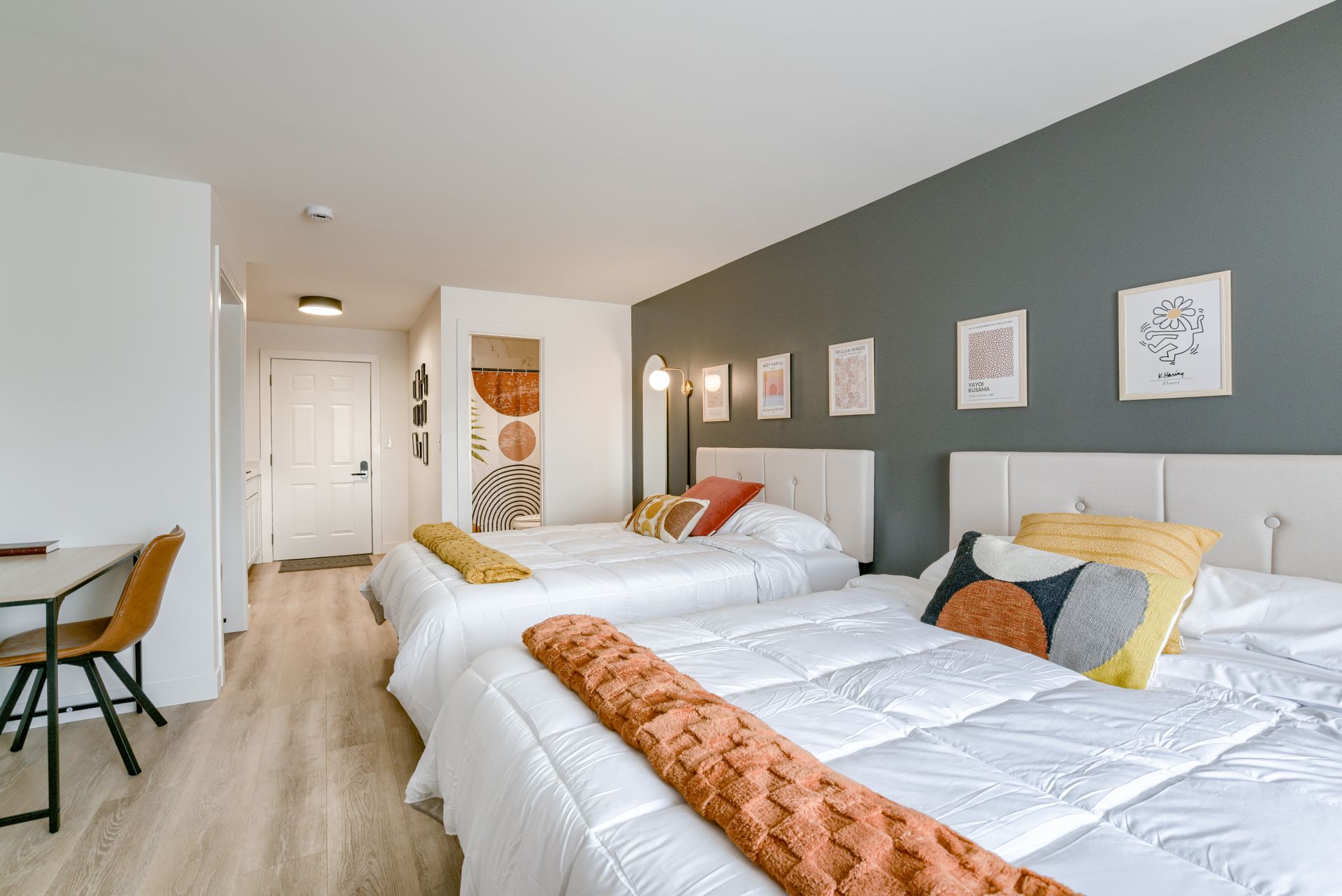 A hotel room with two beds and a desk.