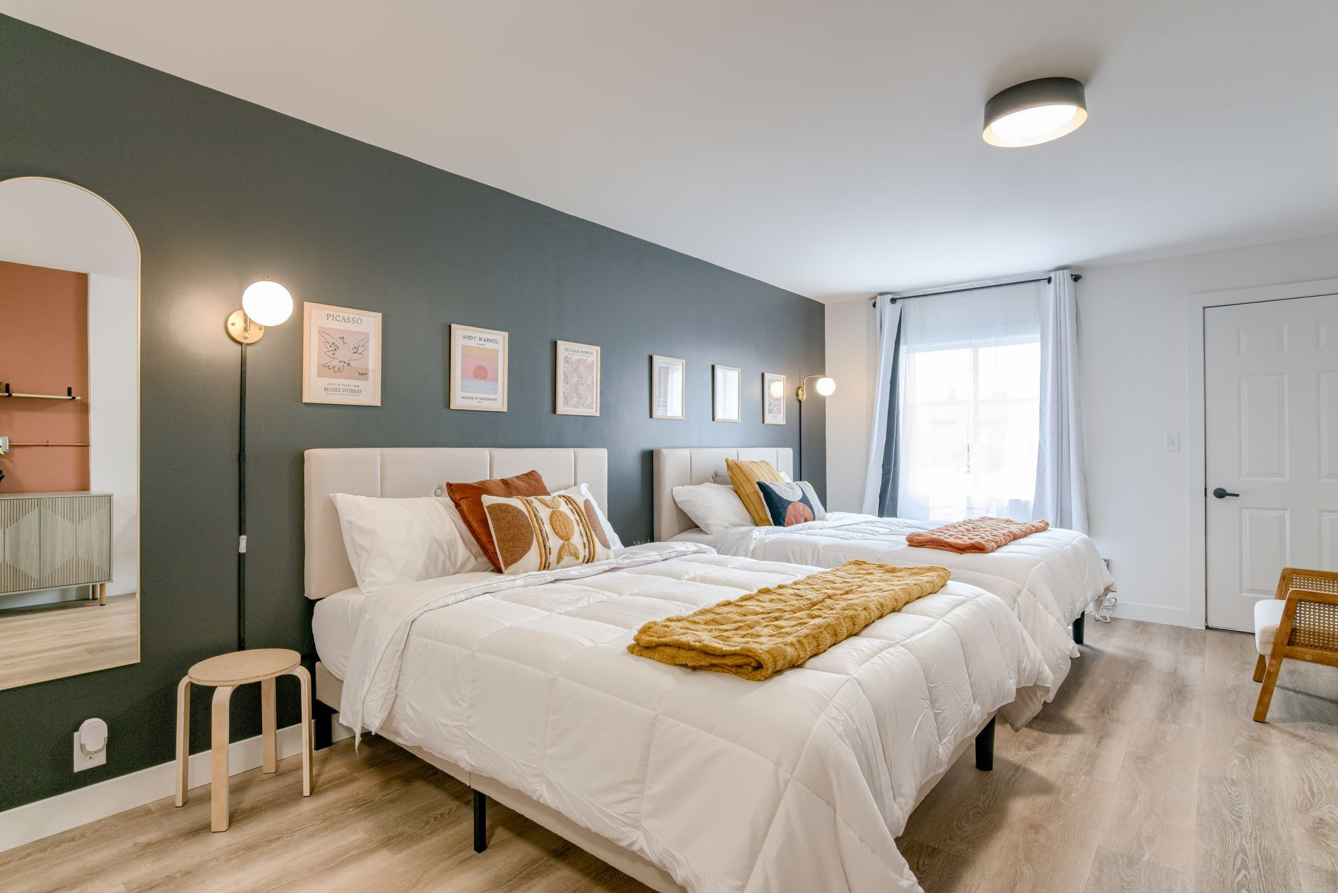 A bedroom with two beds and a large window.