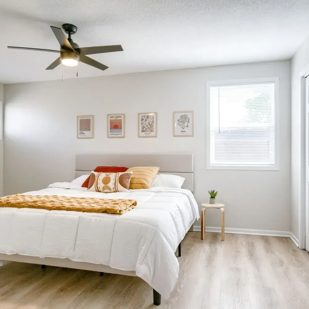 A bedroom with a bed and a ceiling fan