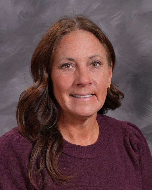 Woman with long dark hair smiling for the camera