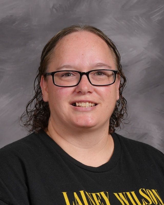 A woman wearing glasses and a purple shirt