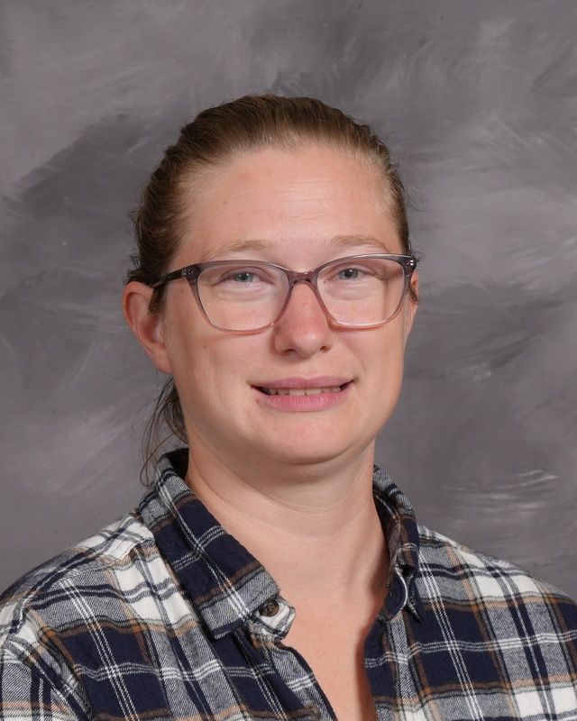 A woman wearing a blue shirt smiling for the camera