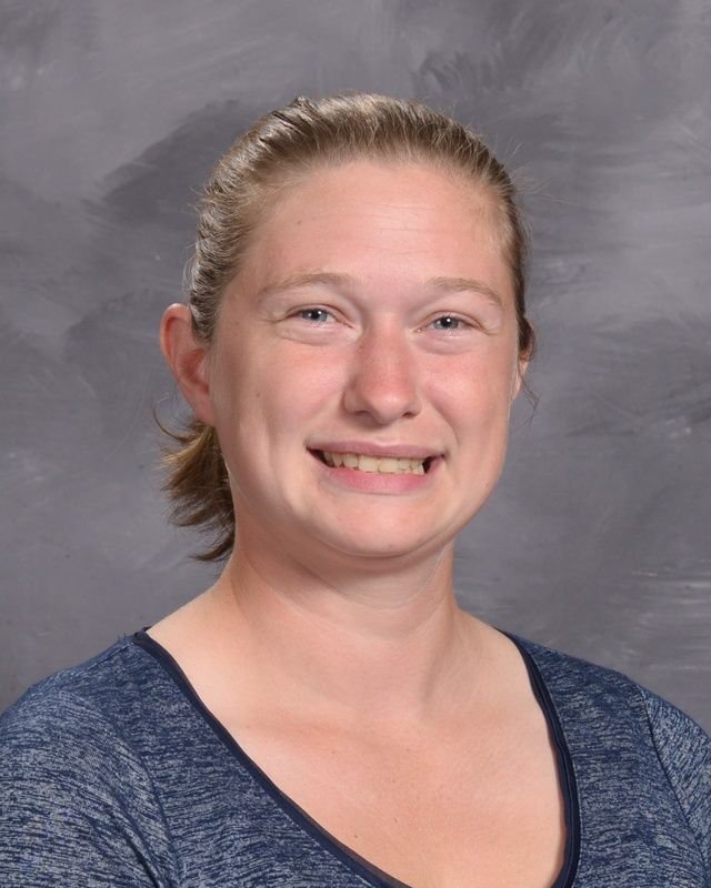 A woman wearing a blue shirt smiling for the camera