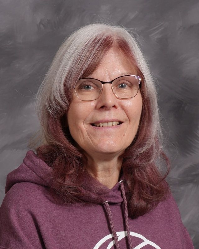 Woman wearing glasses and a maroon hoodie posing for the camera
