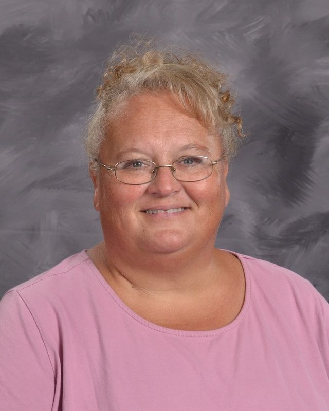 A woman wearing glasses smiles for the camera