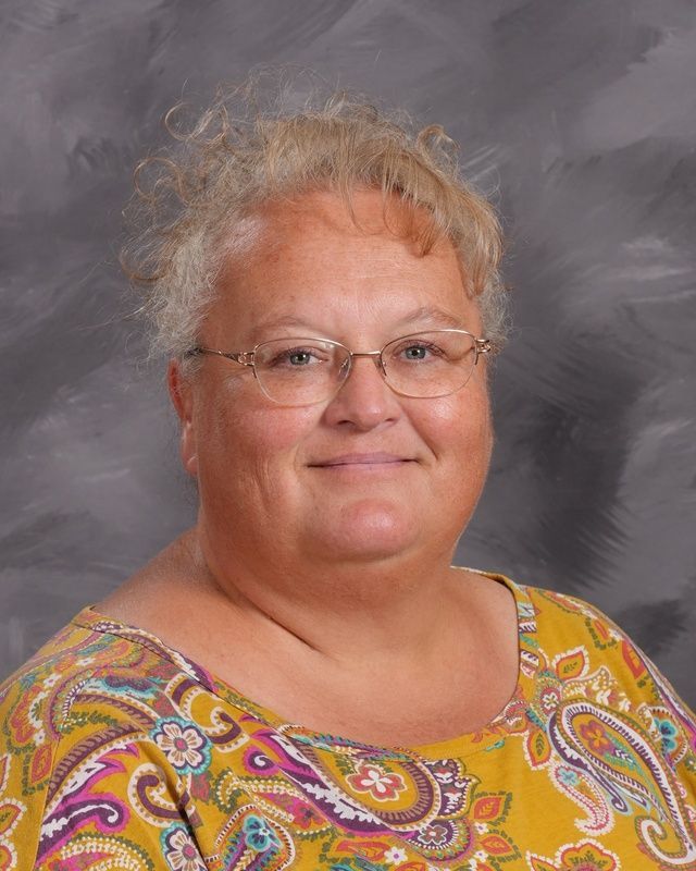 A woman wearing glasses smiles for the camera