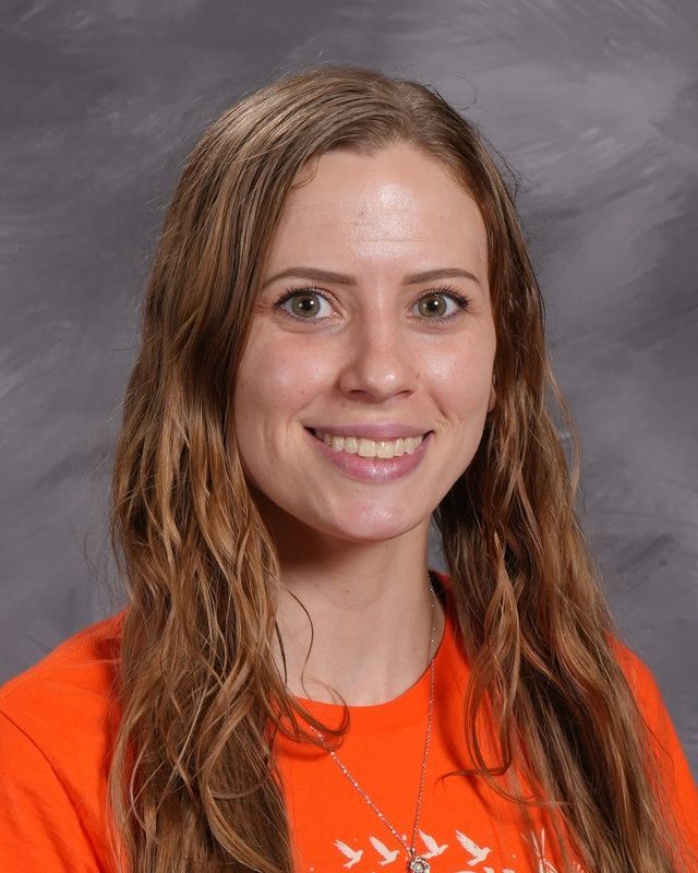 A woman in a black shirt is smiling for the camera.