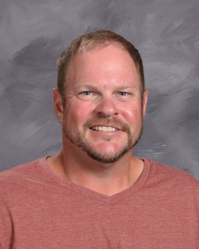 A man with a short beard smiling for the camera